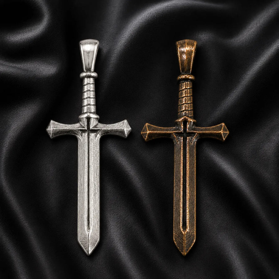 Two Cross & Sword pendants, one silver and one bronze, on a black satin background.