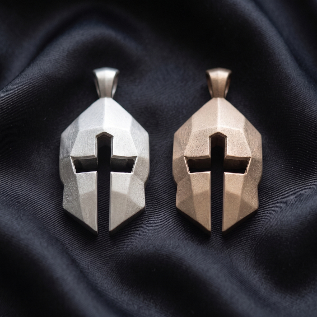 Silver and bronze Cross & Helm pendants side by side on black satin