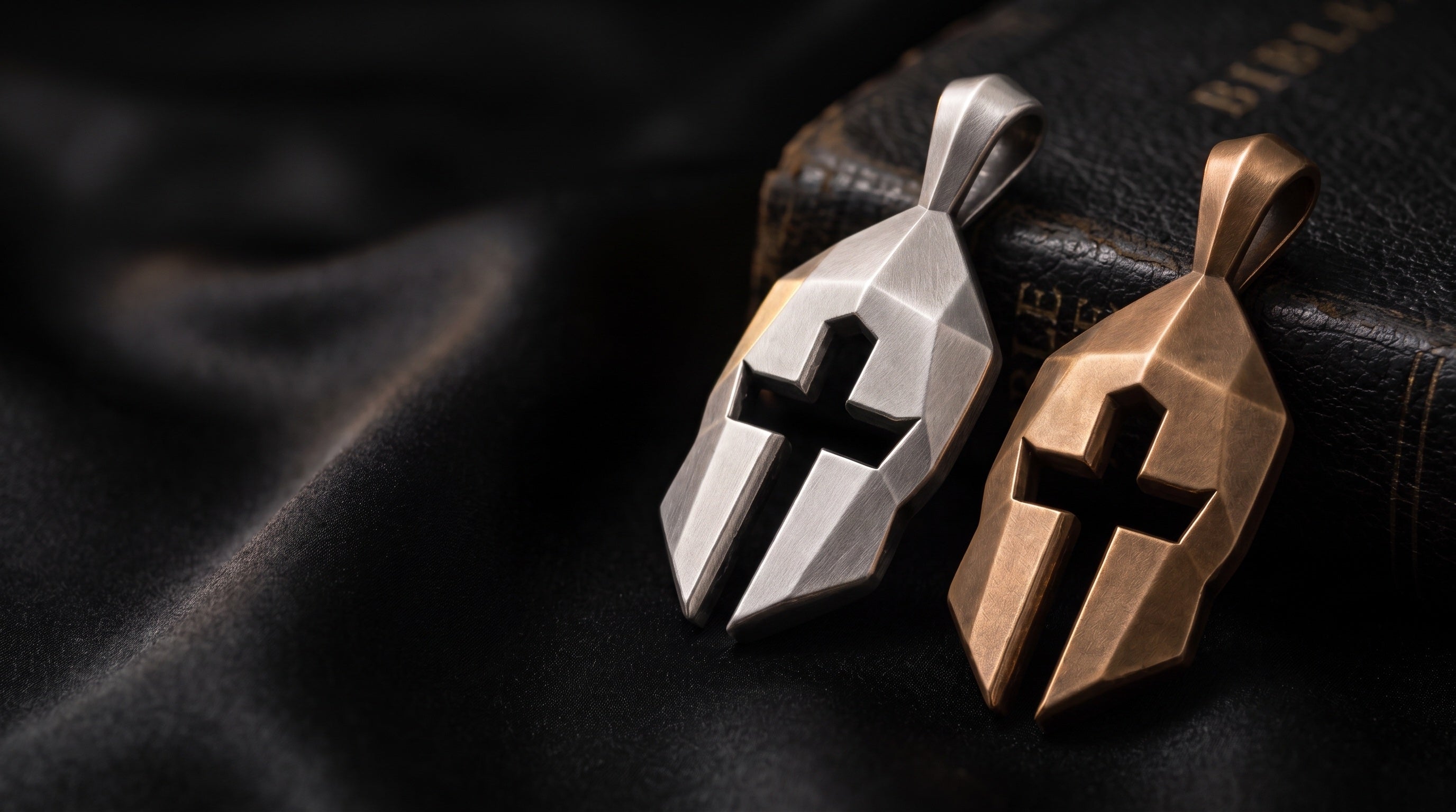 Cross & Helm silver and bronze pendants resting against a worn leather Bible
